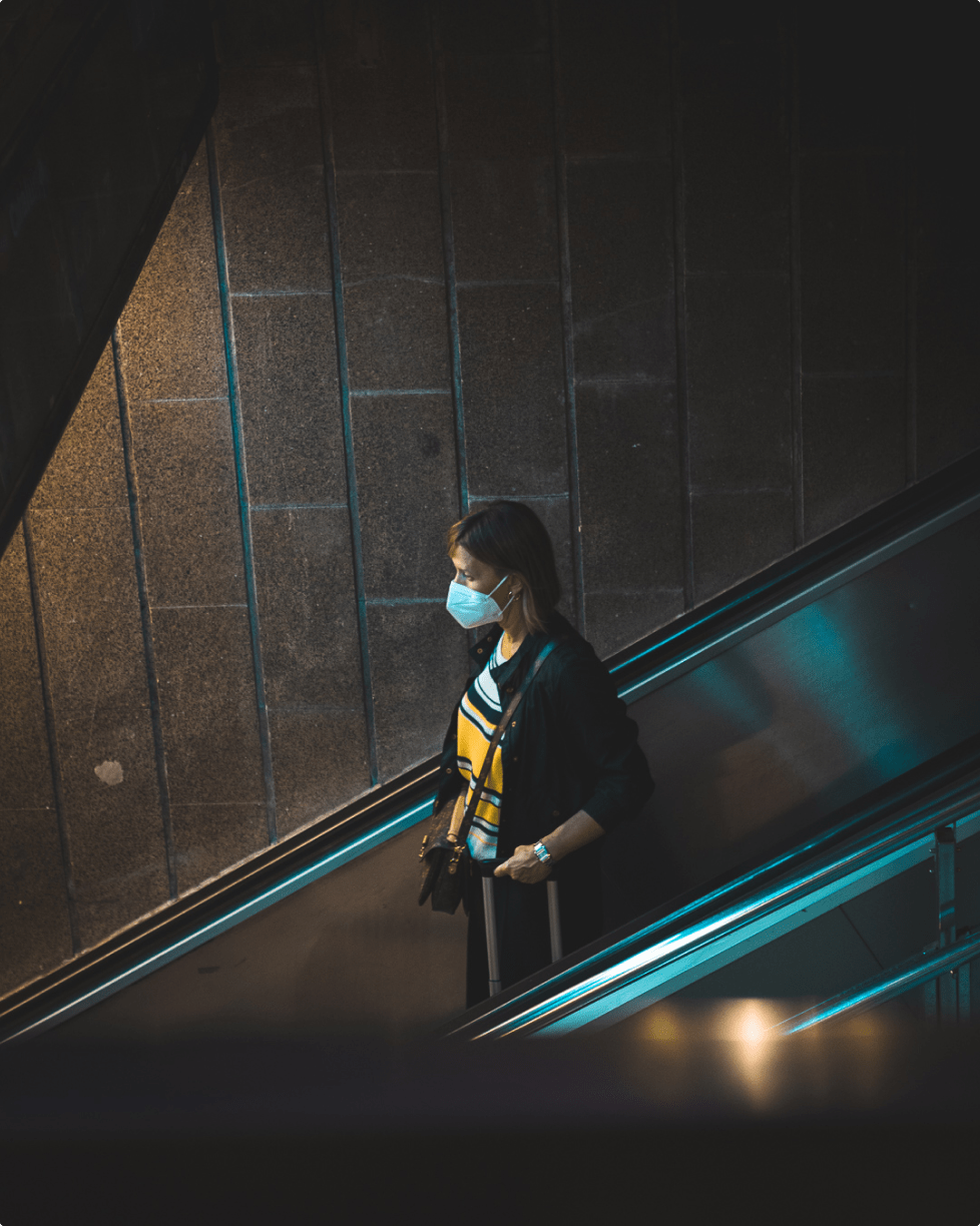 woman with a mask going down the stairs - photo by David Gallardo