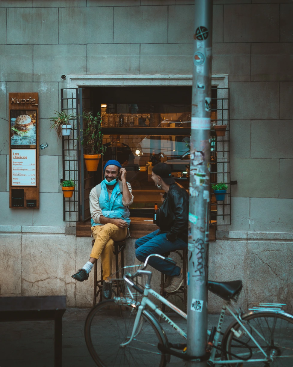 two man laughing in a bar terrace - photo by David Gallardo